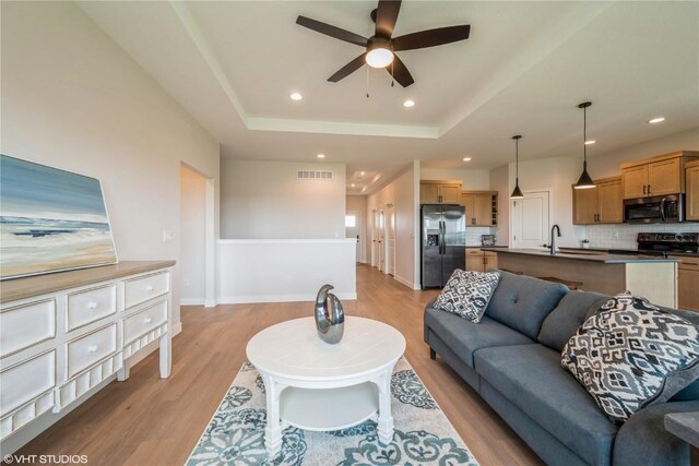 2559 Bluegrass St, Marion, IA 52302 - living room featuring light wood-style floors, a ceiling fan, recessed lighting, a raised ceiling, and baseboards