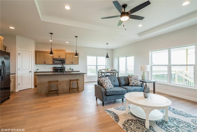 2559 Bluegrass St, Marion, IA 52302 - living room with a tray ceiling, recessed lighting, light wood finished floors, ceiling fan, and baseboards