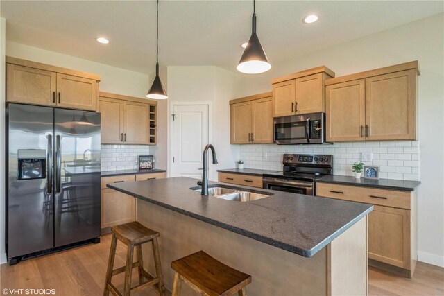 2559 Bluegrass St, Marion, IA 52302 - kitchen featuring appliances with stainless steel finishes, a sink, dark countertops, light wood-style floors, and recessed lighting