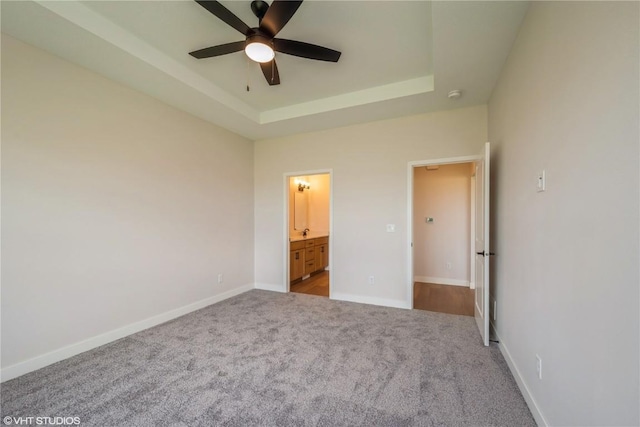 2559 Bluegrass St, Marion, IA 52302 - unfurnished bedroom featuring a tray ceiling, carpet, ensuite bath, baseboards, and ceiling fan