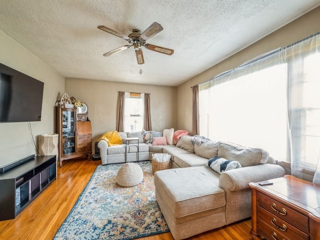 404 3rd St, Keystone, IA 52249 - living room featuring a ceiling fan, a textured ceiling, and wood finished floors