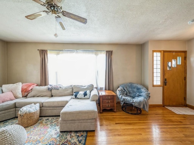 404 3rd St, Keystone, IA 52249 - living area with wood finished floors, a textured ceiling, plenty of natural light, a ceiling fan, and baseboards