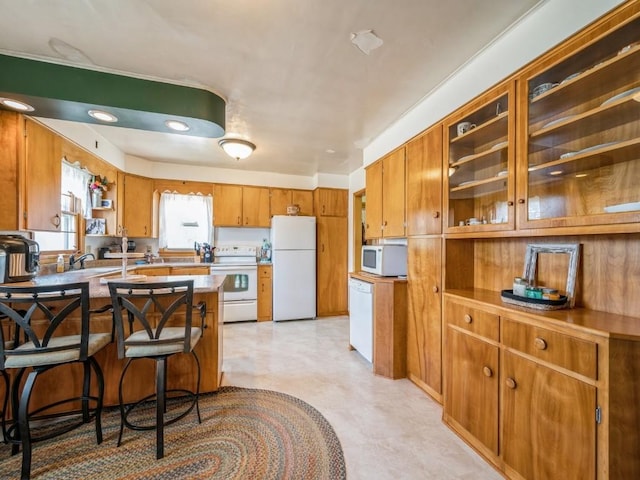 404 3rd St, Keystone, IA 52249 - kitchen with white appliances, brown cabinets, light countertops, light flooring, and a peninsula