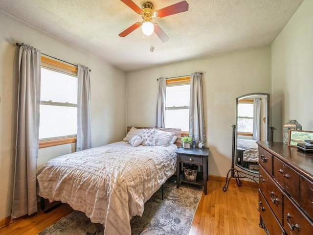404 3rd St, Keystone, IA 52249 - bedroom featuring light wood finished floors, a ceiling fan, a textured ceiling, and baseboards