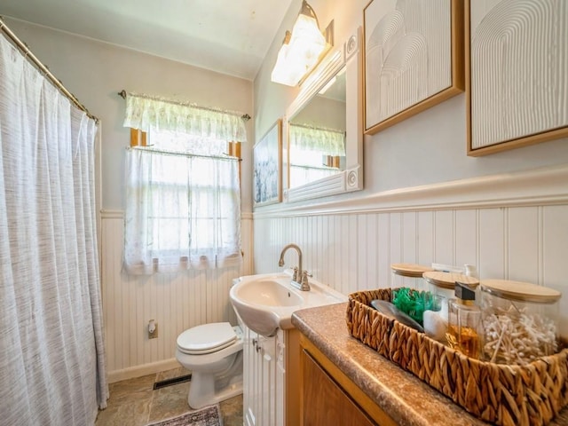 404 3rd St, Keystone, IA 52249 - full bathroom with wainscoting, toilet, a shower with shower curtain, vanity, and stone finish flooring