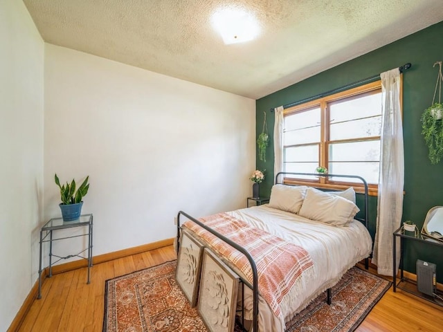 404 3rd St, Keystone, IA 52249 - bedroom with a textured ceiling, wood finished floors, and baseboards