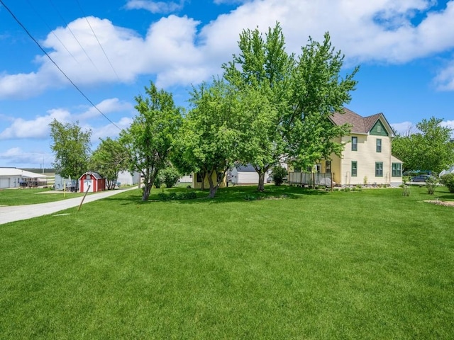 404 3rd St, Keystone, IA 52249 - view of green lawn featuring concrete driveway and an outbuilding