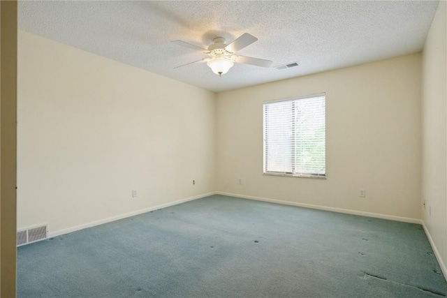 carpeted spare room featuring ceiling fan, baseboards, and a textured ceiling