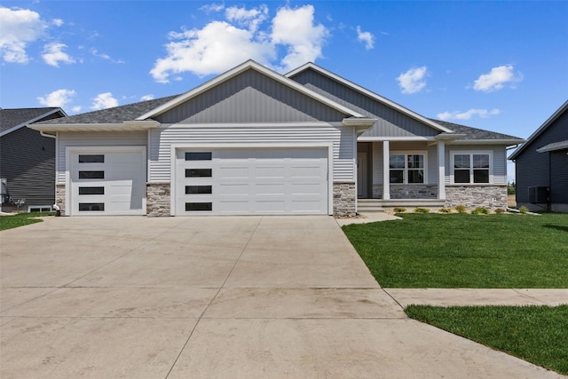 1356 Hickory Ridge Dr, Marion, IA 52302 - view of front of property with stone siding, a garage, a front yard, and concrete driveway