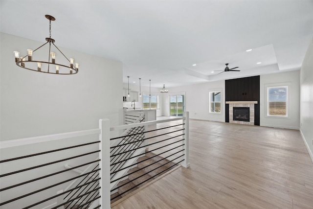 1356 Hickory Ridge Dr, Marion, IA 52302 - hall featuring an upstairs landing, a chandelier, a tray ceiling, recessed lighting, and light wood-style flooring