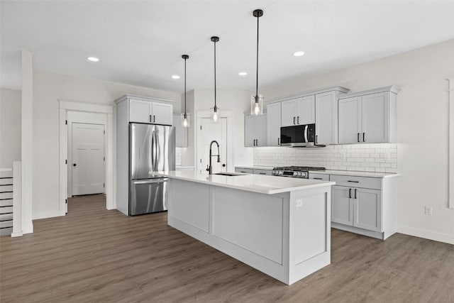 1356 Hickory Ridge Dr, Marion, IA 52302 - kitchen featuring appliances with stainless steel finishes, a sink, wood finished floors, light countertops, and tasteful backsplash