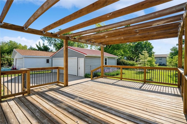 wooden deck featuring an outbuilding, a detached garage, and a pergola