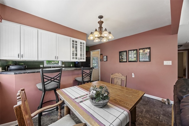 dining area featuring a chandelier and baseboards