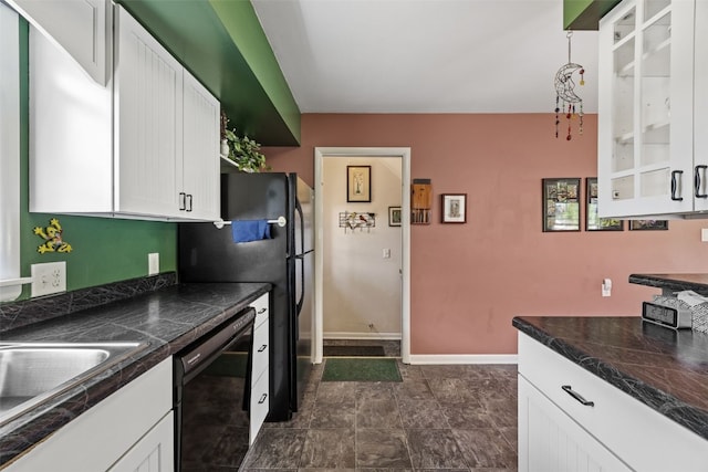 kitchen featuring black dishwasher, white cabinetry, dark countertops, baseboards, and a sink