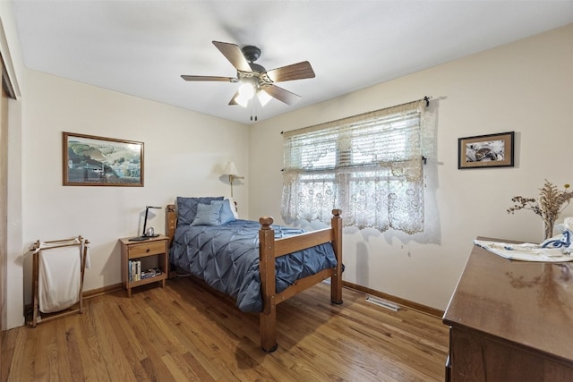 bedroom with light wood-style floors, baseboards, and a ceiling fan