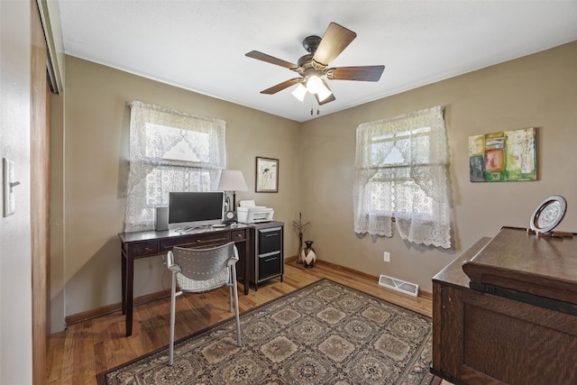 home office featuring light wood-style flooring, a ceiling fan, and baseboards