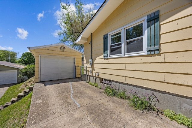 view of side of property with driveway, an outbuilding, and a garage