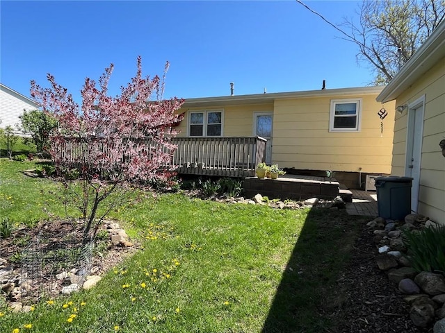 back of house featuring a wooden deck and a yard