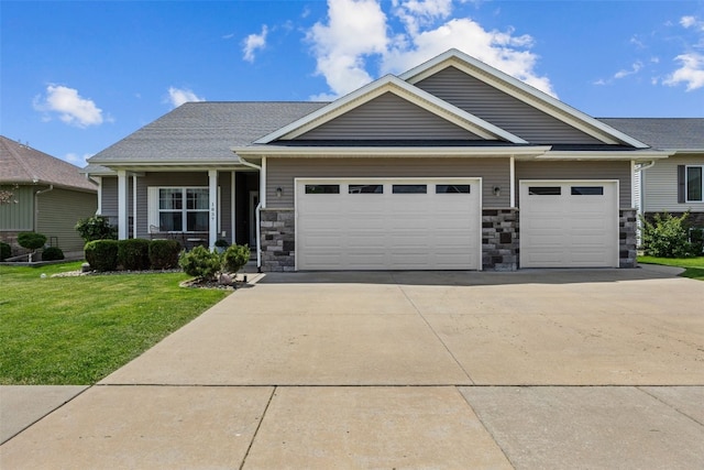 craftsman house with a garage, driveway, a front lawn, and stone siding