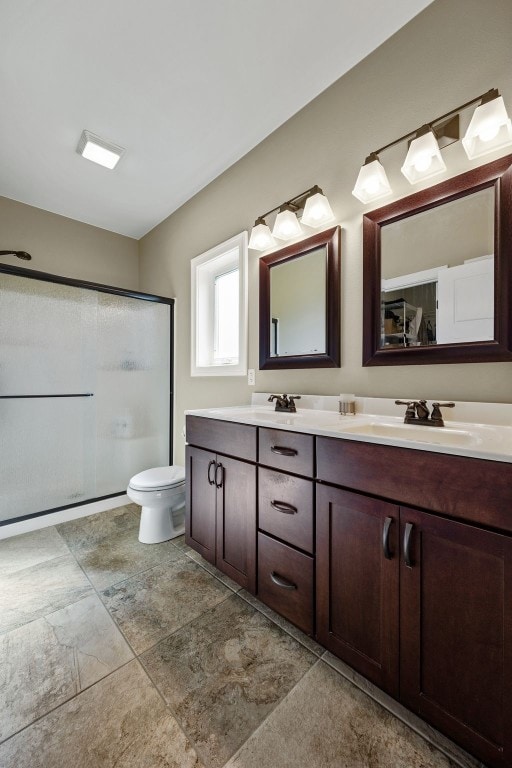 full bathroom featuring a stall shower, double vanity, and toilet
