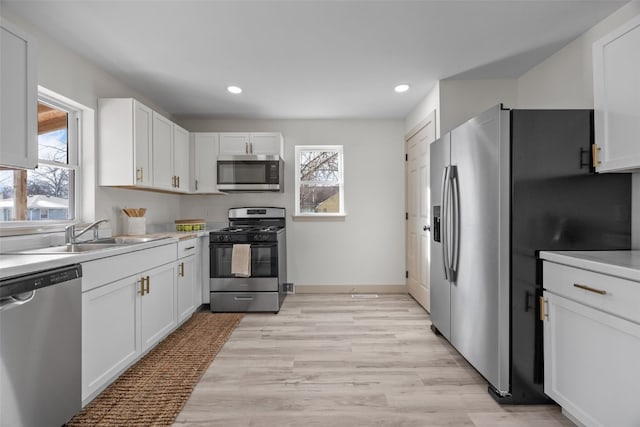 841 S 7th St, Iowa City, IA 52240 - kitchen featuring stainless steel appliances, a sink, healthy amount of natural light, white cabinets, and recessed lighting