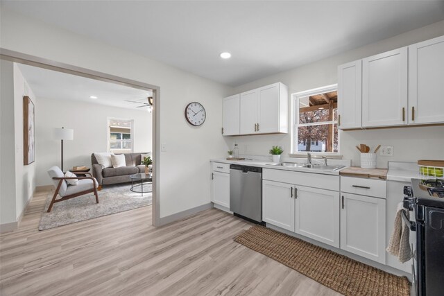 841 S 7th St, Iowa City, IA 52240 - kitchen featuring stainless steel dishwasher, a sink, black gas range oven, white cabinets, and light wood-style flooring