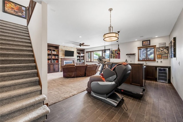 302 6th St NE, Mount Vernon, IA 52314 - exercise room with beverage cooler, dark wood-type flooring, a large fireplace, built in shelves, and recessed lighting