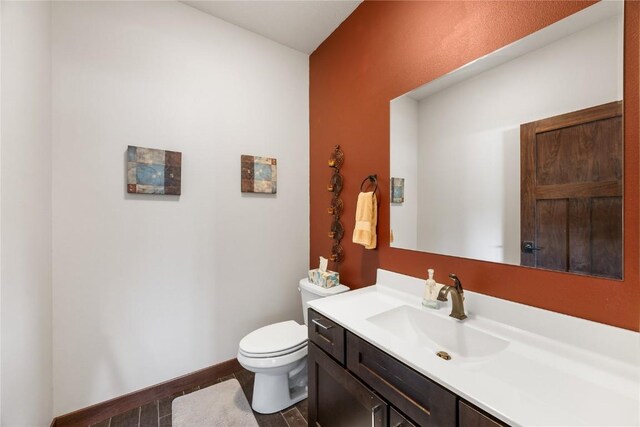 302 6th St NE, Mount Vernon, IA 52314 - bathroom featuring toilet, vanity, and baseboards