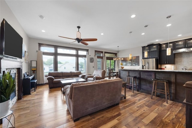 302 6th St NE, Mount Vernon, IA 52314 - living area featuring a glass covered fireplace, a ceiling fan, wood-type flooring, and recessed lighting
