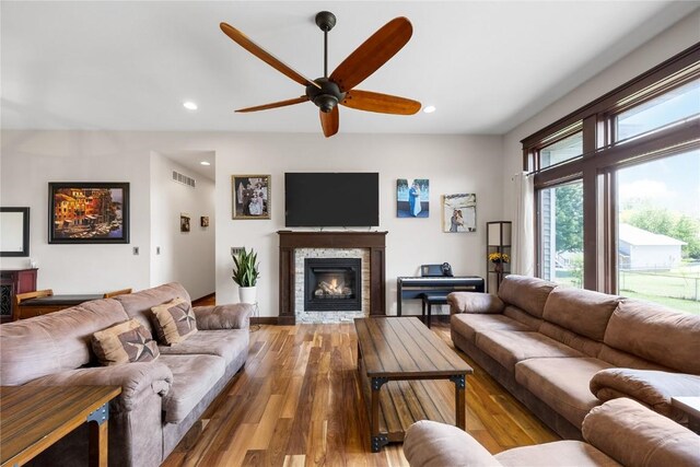 302 6th St NE, Mount Vernon, IA 52314 - living room with a ceiling fan, wood finished floors, recessed lighting, and a stone fireplace