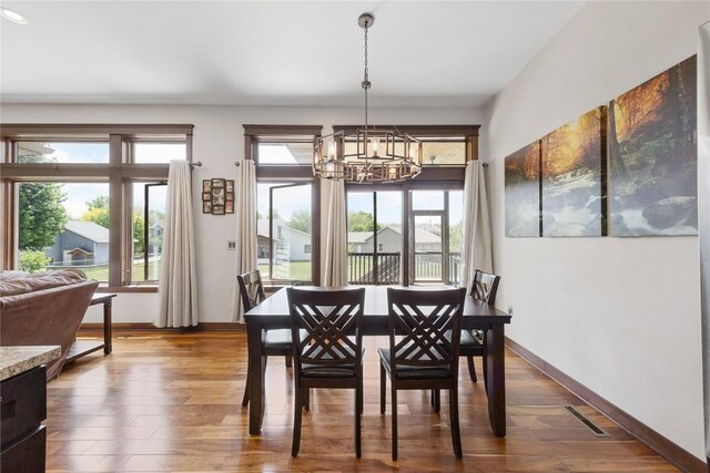 302 6th St NE, Mount Vernon, IA 52314 - dining area featuring a chandelier, dark wood-style flooring, and baseboards