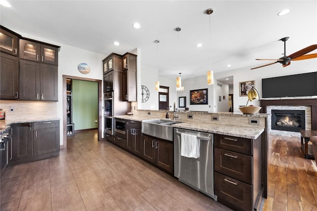302 6th St NE, Mount Vernon, IA 52314 - kitchen with appliances with stainless steel finishes, open floor plan, a sink, a peninsula, and dark brown cabinets
