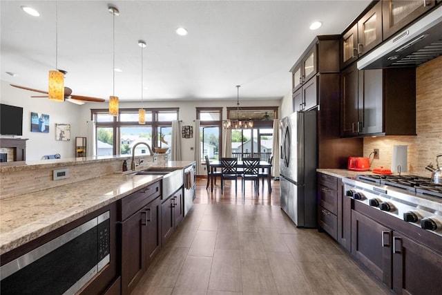 302 6th St NE, Mount Vernon, IA 52314 - kitchen featuring appliances with stainless steel finishes, exhaust hood, a sink, healthy amount of natural light, and recessed lighting