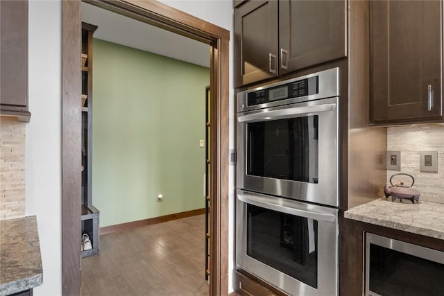302 6th St NE, Mount Vernon, IA 52314 - kitchen featuring stainless steel appliances, dark brown cabinets, decorative backsplash, baseboards, and light countertops