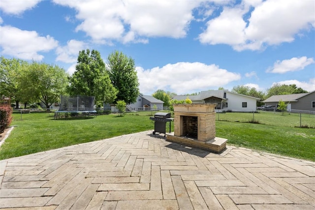 302 6th St NE, Mount Vernon, IA 52314 - view of patio featuring exterior fireplace, a grill, a trampoline, and a wooden deck