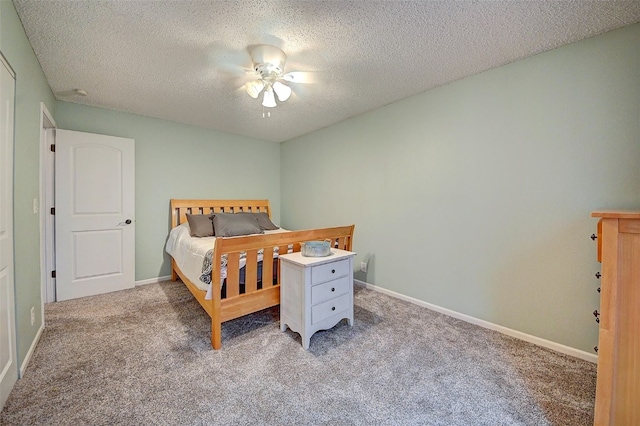 bedroom featuring carpet, a textured ceiling, baseboards, and a ceiling fan