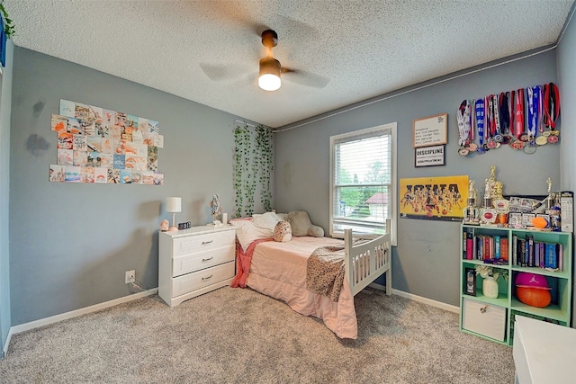 carpeted bedroom with a textured ceiling, a ceiling fan, and baseboards