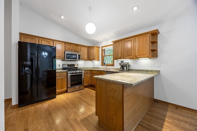 1451 Chamberlain Dr, Iowa City, IA 52240 - kitchen featuring stainless steel appliances, a peninsula, brown cabinetry, vaulted ceiling, and pendant lighting