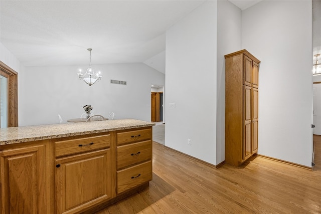 1451 Chamberlain Dr, Iowa City, IA 52240 - kitchen featuring light wood finished floors, a chandelier, brown cabinetry, pendant lighting, and baseboards
