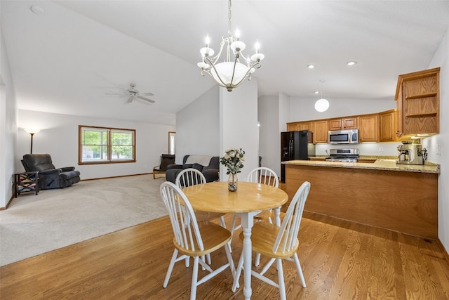 1451 Chamberlain Dr, Iowa City, IA 52240 - dining space featuring vaulted ceiling, light wood finished floors, a ceiling fan, baseboards, and a chandelier