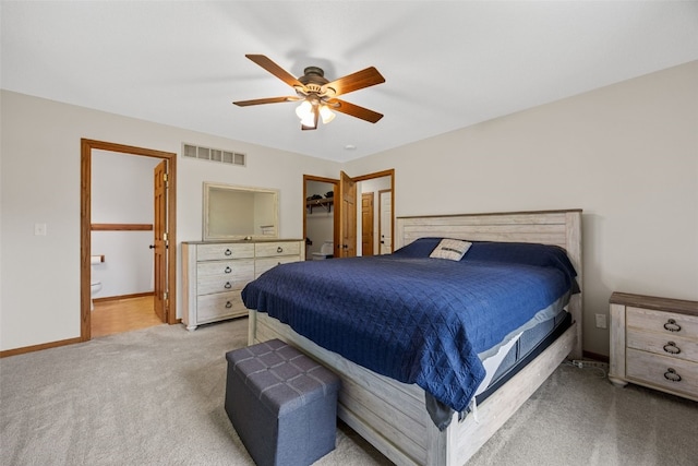 1451 Chamberlain Dr, Iowa City, IA 52240 - bedroom with carpet, ceiling fan, baseboards, a walk in closet, and ensuite bathroom