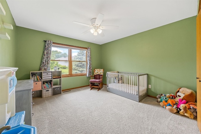 1451 Chamberlain Dr, Iowa City, IA 52240 - carpeted bedroom featuring baseboards, a ceiling fan, a crib, and a water view