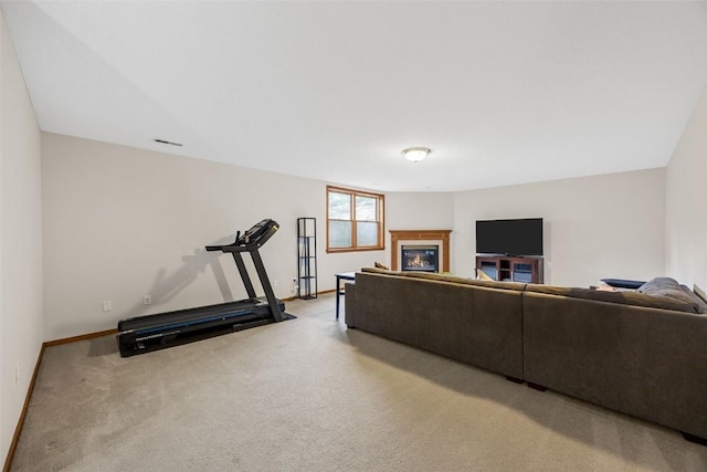 1451 Chamberlain Dr, Iowa City, IA 52240 - living area featuring a glass covered fireplace, light carpet, and baseboards