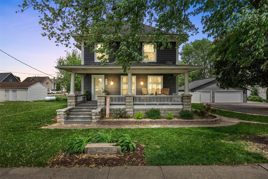 243 N Main Ave, Alburnett, IA 52202 - american foursquare style home with a porch, a front yard, and a detached garage