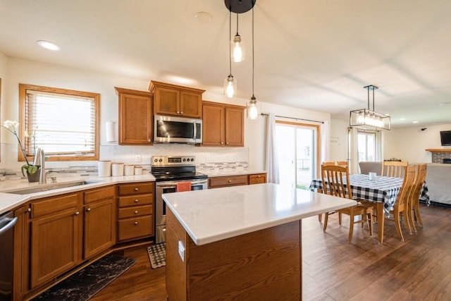 7213 Rolling Ridge Dr SW, Cedar Rapids, IA 52404 - kitchen featuring stainless steel appliances, a sink, brown cabinets, dark wood-style floors, and tasteful backsplash