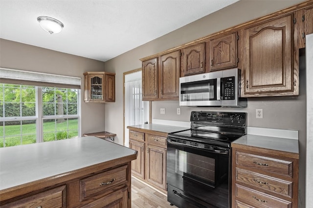 3445 Willowridge Rd Unit B, Marion, IA 52302 - kitchen featuring black electric range, stainless steel microwave, and light wood-type flooring