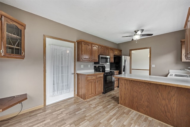 3445 Willowridge Rd Unit B, Marion, IA 52302 - kitchen featuring black range with electric cooktop, stainless steel microwave, a sink, fridge with ice dispenser, and light wood-style floors
