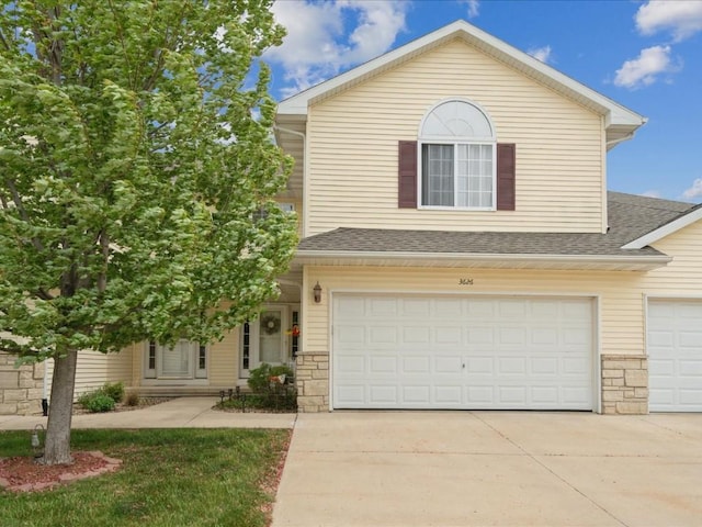 3626 Stoneview Cir SW, Cedar Rapids, IA 52404 - view of front of property with concrete driveway, an attached garage, a shingled roof, and stone siding