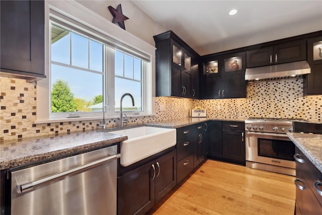 1443 69th St, Keystone, IA 52249 - kitchen featuring appliances with stainless steel finishes, under cabinet range hood, a sink, decorative backsplash, and recessed lighting