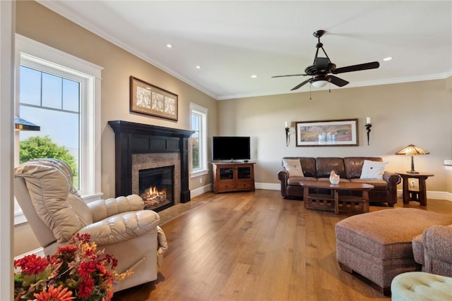 1443 69th St, Keystone, IA 52249 - living area featuring light wood-style flooring, a glass covered fireplace, ceiling fan, recessed lighting, and ornamental molding